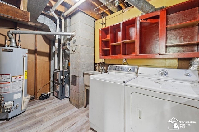 laundry area featuring light wood-type flooring, gas water heater, washer and clothes dryer, and sink