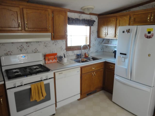 kitchen with white appliances, range hood, lofted ceiling, and sink