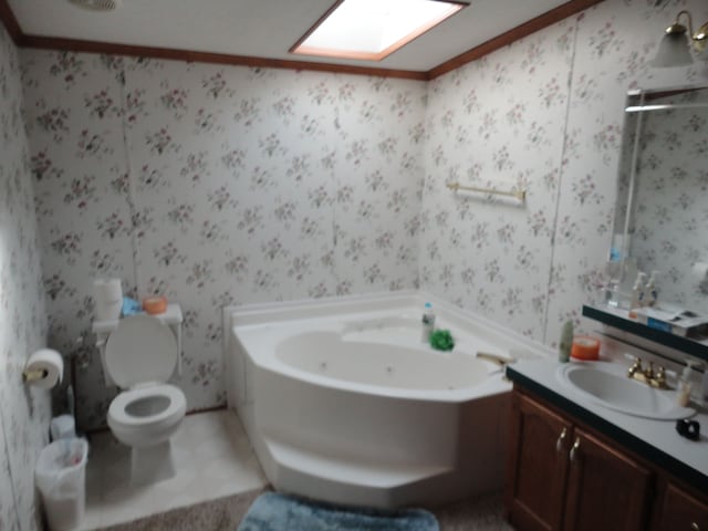 bathroom with a bathing tub, tile patterned floors, toilet, vanity, and ornamental molding