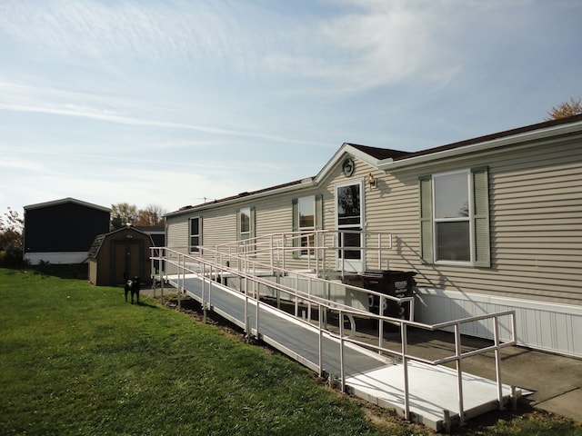 back of property featuring a shed and a yard