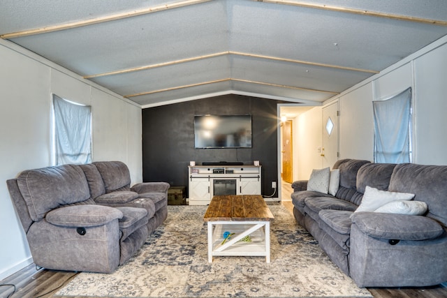 living room featuring a textured ceiling, hardwood / wood-style flooring, and lofted ceiling