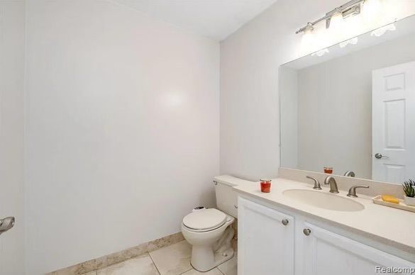 bathroom featuring tile patterned floors, vanity, and toilet