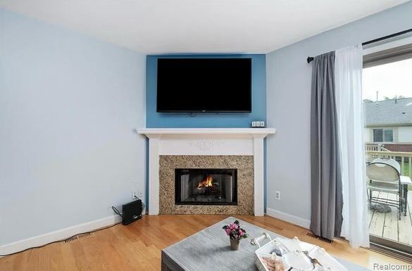 living room featuring wood-type flooring and a fireplace