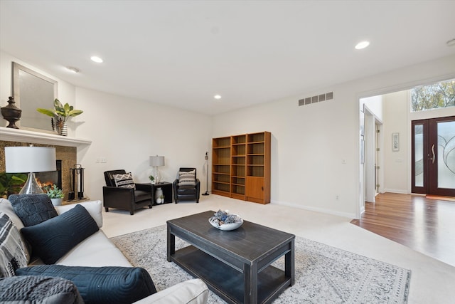 living room with light wood-type flooring and a high end fireplace