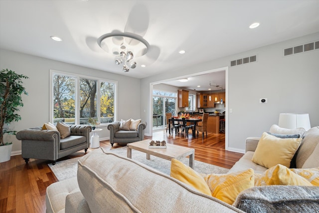 living room with a notable chandelier and dark hardwood / wood-style floors