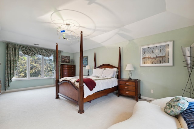 bedroom with a tray ceiling and light colored carpet