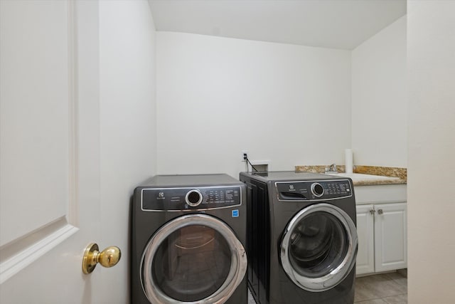 laundry area featuring light tile patterned flooring, cabinets, sink, and washing machine and clothes dryer