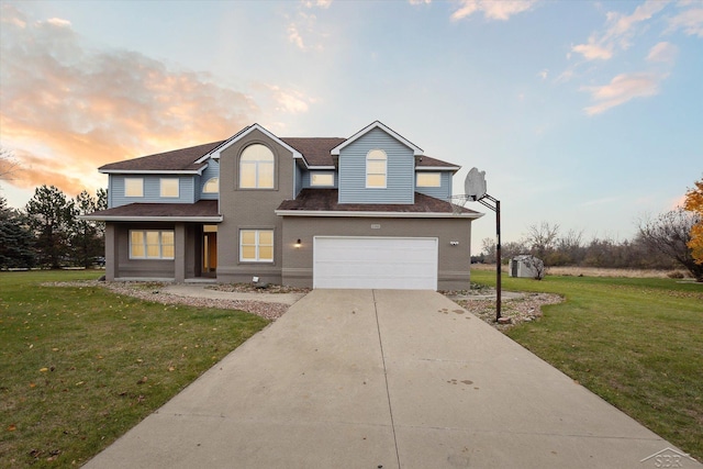 view of front of property with a garage and a lawn