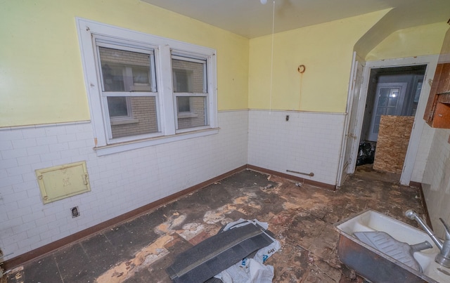 spare room featuring tile walls