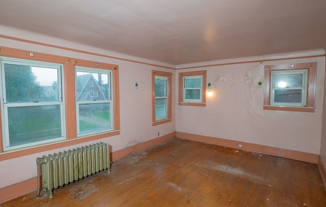 spare room with radiator heating unit and hardwood / wood-style floors