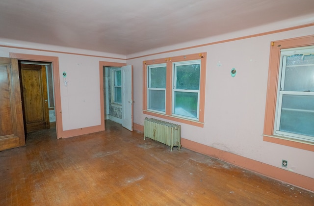 unfurnished room featuring hardwood / wood-style flooring and radiator