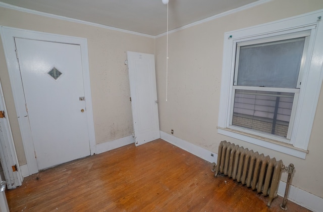 entryway featuring radiator, crown molding, and hardwood / wood-style flooring