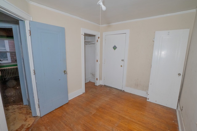 unfurnished bedroom with crown molding and light hardwood / wood-style flooring