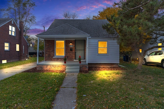 bungalow-style home with a porch and a lawn