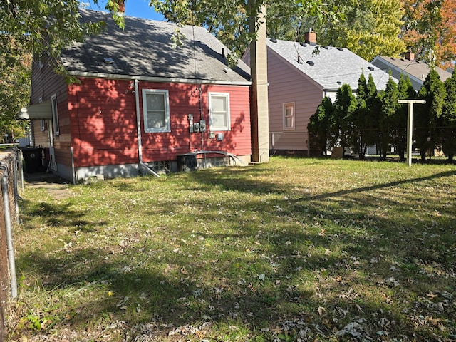 rear view of property featuring a lawn