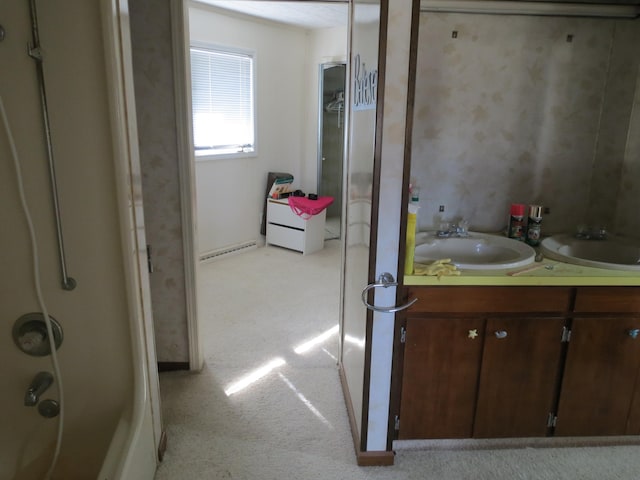 bathroom with a shower with door, vanity, and a baseboard heating unit