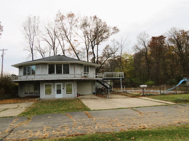 view of front of property featuring a playground and a garage