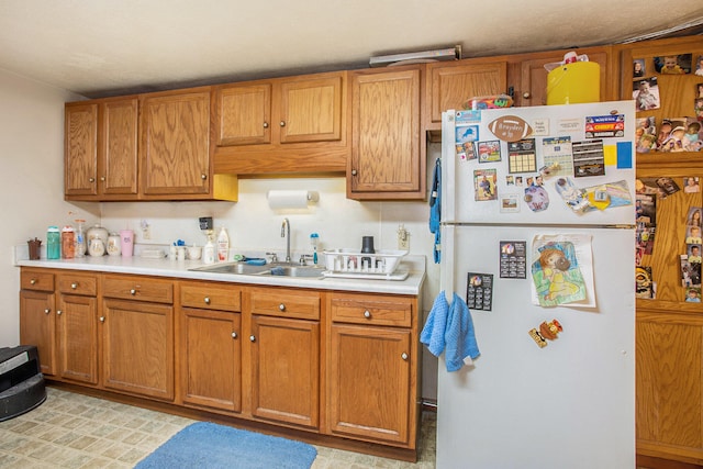 kitchen featuring white refrigerator and sink