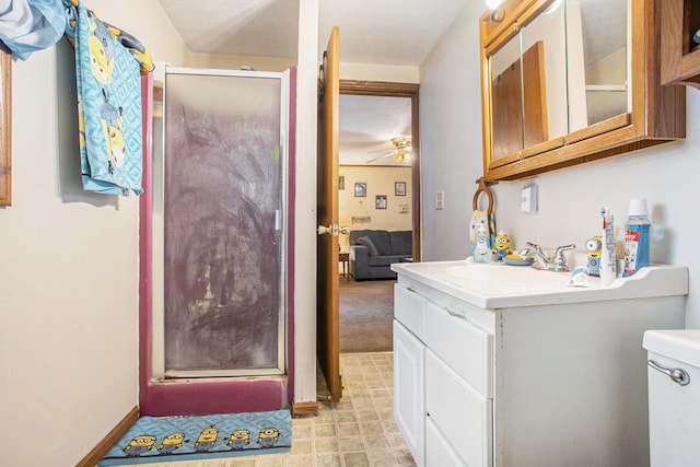 bathroom featuring ceiling fan, vanity, an enclosed shower, and toilet