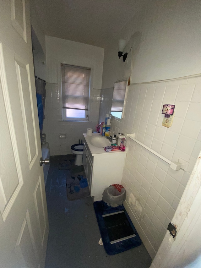 bathroom featuring a shower with shower curtain, vanity, toilet, and tile walls