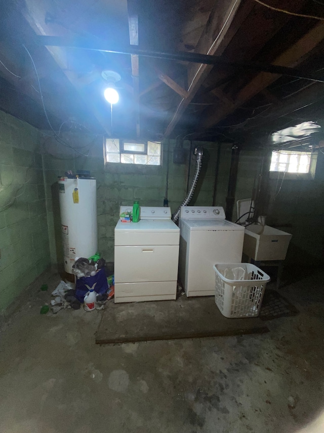 basement with water heater, washer and clothes dryer, and sink