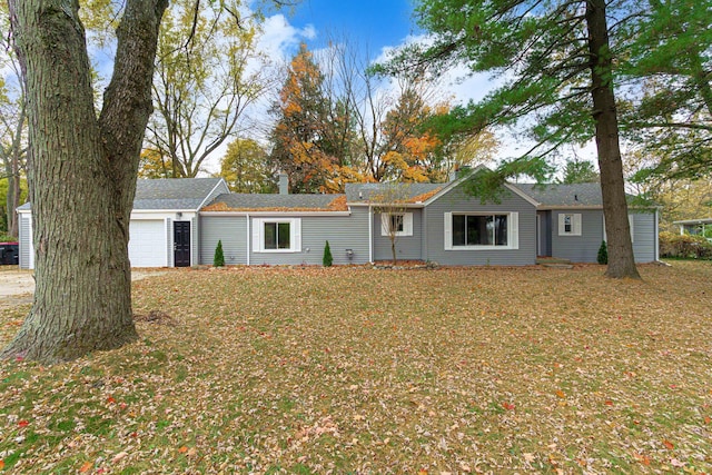 ranch-style house featuring a garage and a front lawn