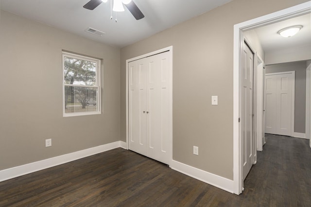 unfurnished bedroom featuring ceiling fan, a closet, and dark hardwood / wood-style floors