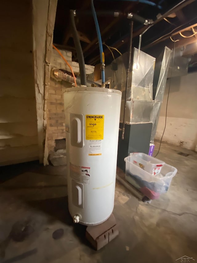 utility room featuring heating unit and electric water heater