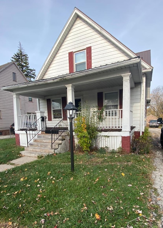 bungalow-style home with a porch and a front yard