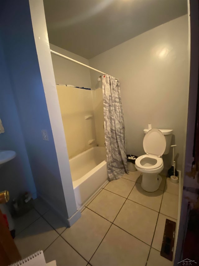 bathroom with tile patterned floors, shower / tub combo, and toilet