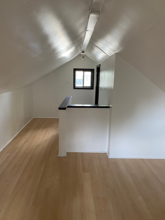 bonus room with light hardwood / wood-style floors and lofted ceiling