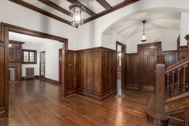 foyer featuring vaulted ceiling with beams, dark hardwood / wood-style floors, ornamental molding, and radiator