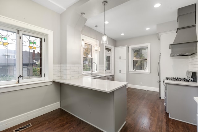 kitchen with premium range hood, kitchen peninsula, backsplash, and hanging light fixtures