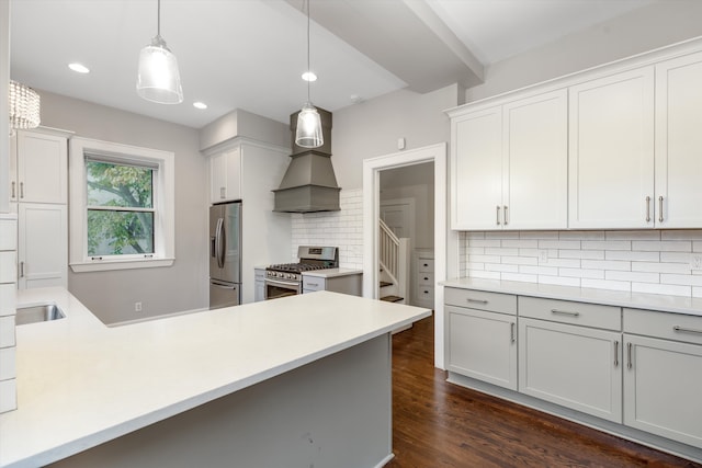 kitchen featuring decorative backsplash, hanging light fixtures, appliances with stainless steel finishes, and dark wood-type flooring