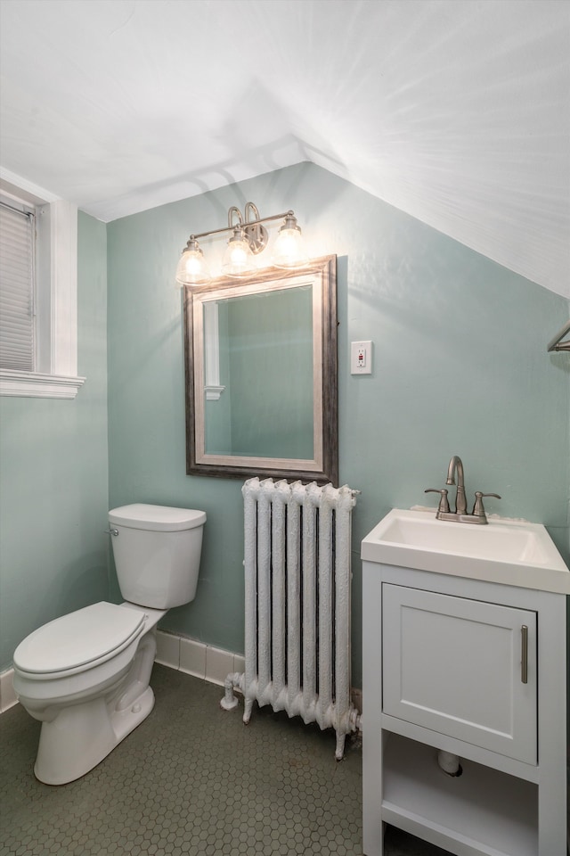 bathroom featuring radiator, vanity, tile patterned flooring, toilet, and lofted ceiling