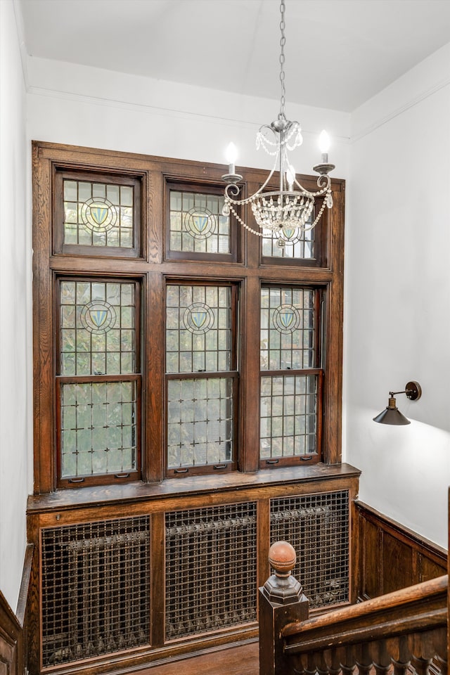 interior space featuring wooden walls and an inviting chandelier