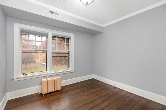 spare room featuring dark hardwood / wood-style floors, crown molding, radiator heating unit, and a textured ceiling