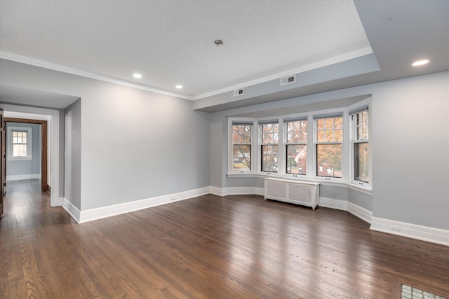 unfurnished room with dark hardwood / wood-style floors, a healthy amount of sunlight, radiator heating unit, and ornamental molding