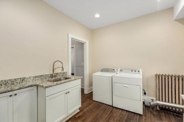 laundry area with cabinets, radiator, sink, separate washer and dryer, and dark hardwood / wood-style flooring