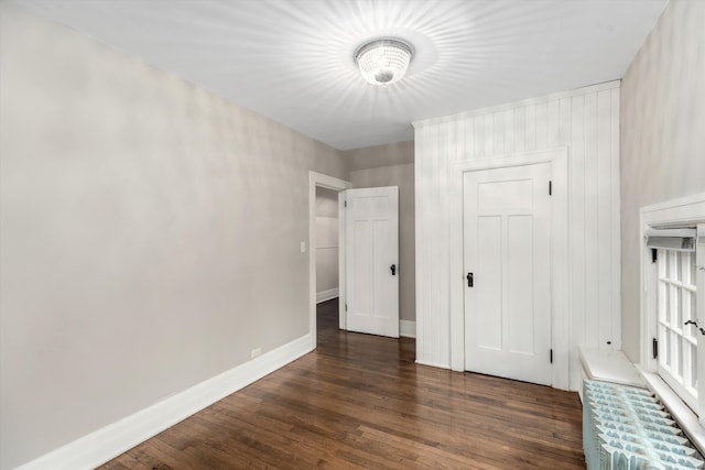 unfurnished bedroom with a closet and dark wood-type flooring