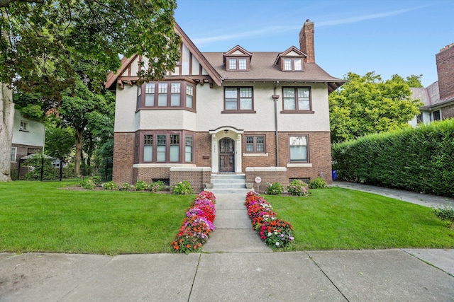 tudor-style house featuring a front yard