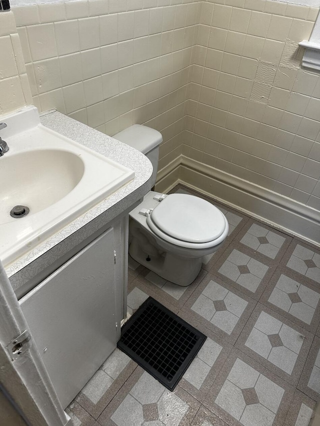 1707 E Stockbridge Ave, Kalamazoo, MI 49001 - half bathroom with tile walls, toilet, and vanity