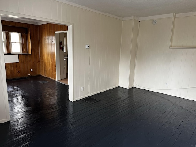 1707 E Stockbridge Ave, Kalamazoo, MI 49001 - unfurnished room featuring dark wood-style floors, baseboards, and wood walls