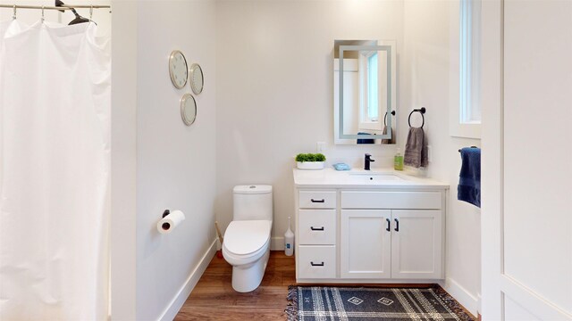 208 Gillis St, Traverse City, MI 49684 - bathroom featuring wood finished floors, vanity, toilet, baseboards, and a shower with shower curtain