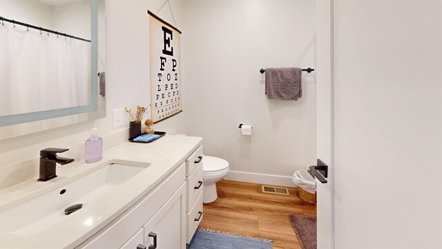 208 Gillis St, Traverse City, MI 49684 - bathroom with vanity, toilet, wood finished floors, baseboards, and curtained shower