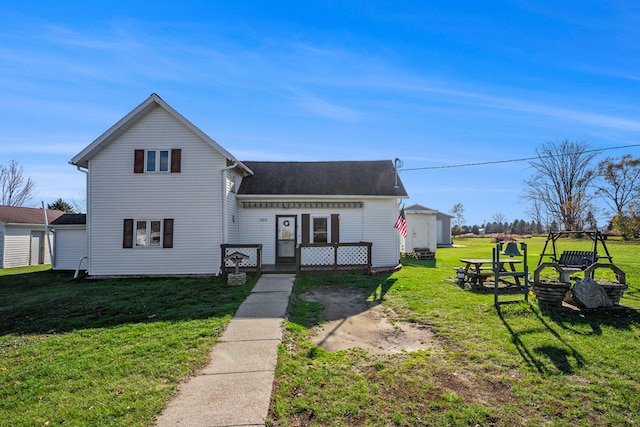 view of front of house featuring a fire pit, a front lawn, and a storage shed