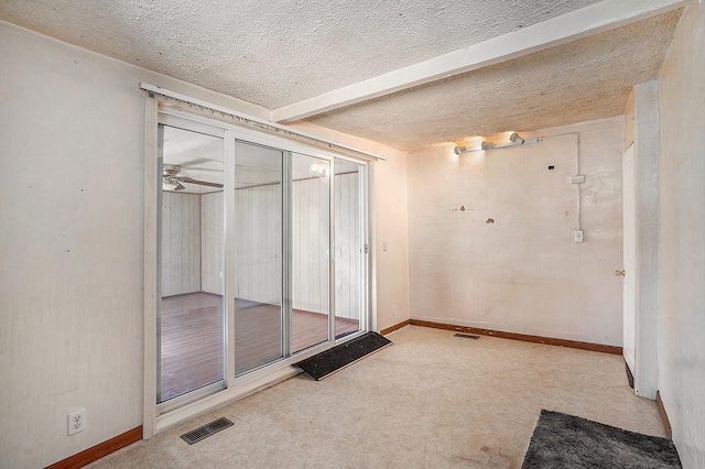 empty room featuring a textured ceiling, carpet floors, and ceiling fan