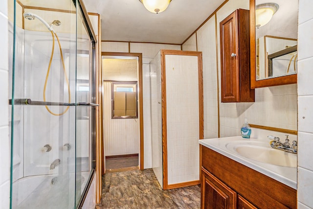 bathroom with tile walls, vanity, and an enclosed shower