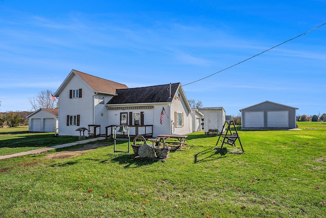 back of house with a lawn, an outbuilding, and a garage