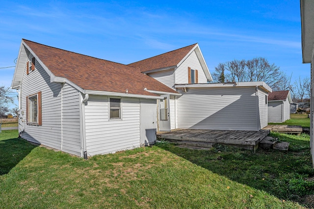 rear view of house featuring a yard and a deck